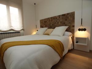 莱昂Apartamentos m.bell的卧室配有一张带两个枕头的大白色床