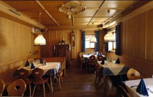 瓦尔道拉Berggasthof Trattes的用餐室配有桌椅和灯光