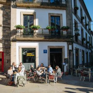 圣地亚哥－德孔波斯特拉阿科德马扎雷洛斯酒店的一群坐在大楼前桌旁的人