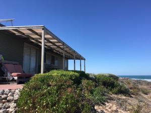 GreenoughPrivate Beach Cottage At Ecostays的海滩上的房子,背景是大海