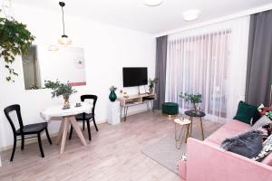 克拉科夫Apartament Arkadia na Kazimierzu的客厅配有粉红色的沙发和桌子