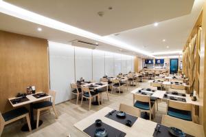 曼谷Artino Hotel - SHA Extra Plus的大型用餐室配有桌椅