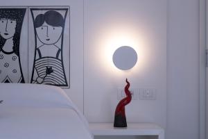 阿马尔菲Zia Pupetta Suites的一间卧室配有一张床和一张桌子上的台灯