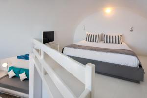 阿克罗蒂里Apanemo Hotel & Suites的一间白色的卧室,配有床和楼梯