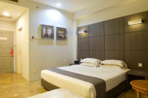 雅加达雅加达梦幻酒店的一间卧室配有一张大床和一张桌子