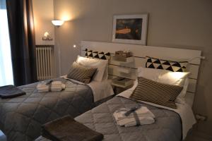 马泰拉Il profumo dei Sassi Holiday Home的一间卧室配有两张带毛巾的床