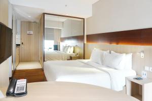 雅加达Ra Premiere Simatupang Jakarta的酒店客房带两张床和电话