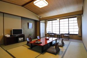 神户有马御苑日式旅馆的客厅配有桌子和电视
