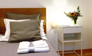 巴勒莫Maqueda331的一张带白色毛巾和花瓶的床