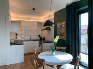 克拉科夫AGIHOME Rajska 3 Apartments的厨房以及带白色桌子的用餐室。