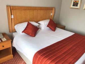 坎伯利湖畔国际酒店的配有两张红色枕头的床的酒店客房