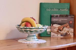 LeibenWilli's Bauernhof的书旁边的桌子上放一碗水果