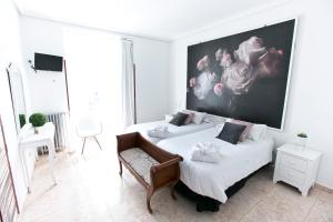 马德里格兰大道巴斯克斯德梅拉旅馆的一间卧室设有两张床,墙上挂着一幅大画