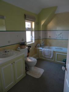 鲍尔多克The Newnham White House的浴室配有卫生间、盥洗盆和浴缸。