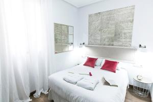 马德里格兰大道巴斯克斯德梅拉旅馆的白色卧室配有一张带红色枕头的大白色床