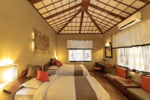 索拉哈绿色庄园丛林度假村的一间卧室设有两张床、一张桌子和窗户。