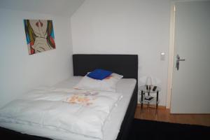 莱茵河畔威尔朗比主教宫酒店的卧室配有一张白色床,墙上挂着一幅画