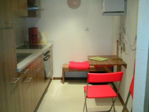 维岑多夫Riggers Hof的一个带红色椅子和桌子的小厨房
