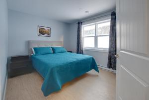 科纳布鲁克Appalachian Chalets & RV的一间卧室配有一张带蓝色床罩的床和窗户。