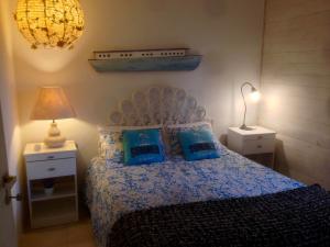 EstherApartamentos El Pintor的一间卧室配有一张带蓝色枕头和一盏灯的床。