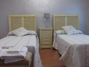 CaleruegaCasa Rural El Torreón II的卧室内两张并排的床