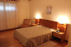 普拉多博玛苏克索酒店的配有一张床和一把椅子的酒店客房