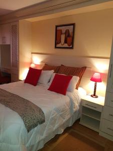 爱德华港Ocean View Villas Unit G02的卧室配有带红色枕头的大型白色床