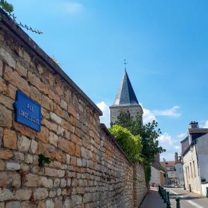 第戎La Bonbonniere - Sure Hotel Collection by Best Western的石墙,有街道标志和教堂陡峭