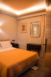 雅典马罗西酒店的卧室配有一张床,墙上设有镜子