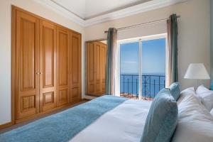 丰沙尔Designed Villa Palheiro Village by HR Madeira的一间卧室设有一张床,享有海景