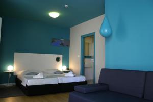 波尔Apartments Villa Azzurra Bol的蓝色的卧室配有床和沙发