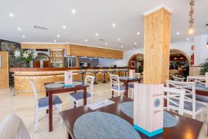 大加那利岛拉斯帕尔马斯和蔼酒店的一间带桌椅的餐厅和一间酒吧