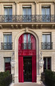 巴黎La Réserve Paris Hotel & Spa的门上用红色窗帘的建筑