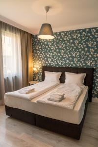 希萨里亚Antique Residence的一间卧室设有一张带花卉墙壁的大床