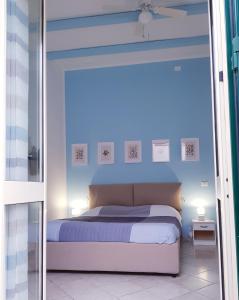 巴勒莫Mondello Home "46 passi"的一间卧室配有一张蓝色墙壁的床