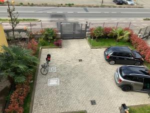 佩罗Relais fiera milano的一个人在停车场里骑着自行车,有两辆车