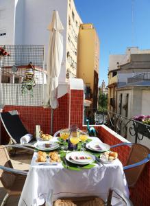 瓦伦西亚Casa Isa的阳台上摆放着食物盘的桌子