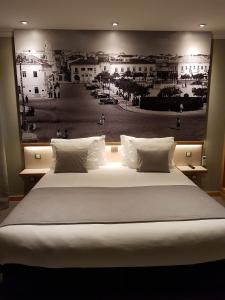 波尔蒂芒NDS Prestige Guest House and Suites - by Rocha Prestige的一张大床,墙上挂着黑白照片