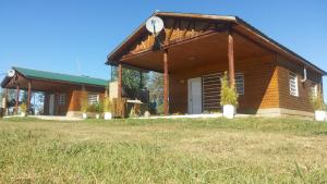 科隆Cabañas Aires de Campos的小木屋设有门廊和草地
