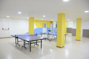 科马鲁加Alberg Coma-ruga Xanascat的黄色柱子的房间,设有两张乒乓球桌