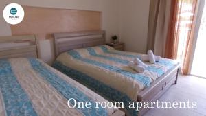 弗尔卡Evridiki Hotel的一间卧室配有两张带毛巾的床
