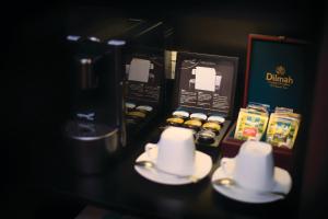 悉尼Central Studio Hotel Sydney的茶几上装有杯子和盘子的咖啡师