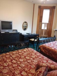 代顿维诺港口住宿加早餐旅馆的一间卧室配有两张床和一张书桌及电视
