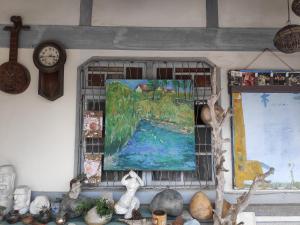 Xingang順耆自然Shun Ci Zih Ran的墙上的画,旁边是钟表和其他物品