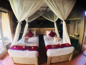佩母德兰Villa Dika Pemuteran的带窗帘的客房内的两张单人床