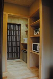 奈良NARAigoto EENA HOUSE的带微波炉和门的小厨房