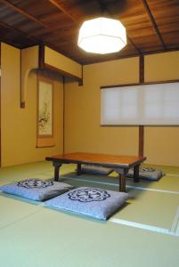 奈良NARAigoto EENA HOUSE的一间设有一张桌子和两张垫子的房间