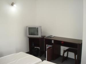 科斯蒂内什蒂Pension Oasis的一间卧室配有书桌和一张书桌上的电视