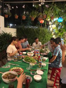 会安An Thinh Homestay的一群坐在餐桌上吃食物的人