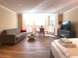 波茨坦Amaroo - Apartments Potsdam “Alexandrowka”的客房设有床、沙发和桌子。
